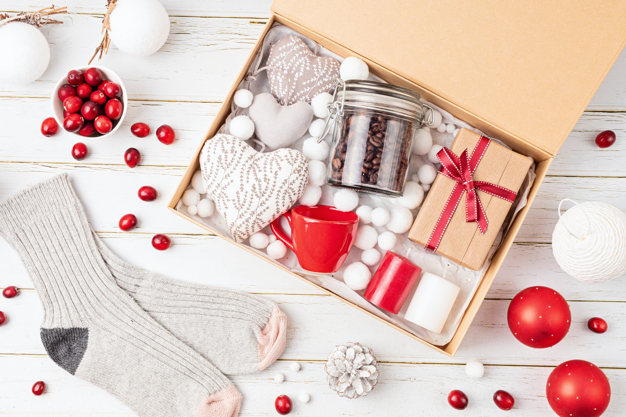 Preparing care package, seasonal gift box with coffee, candles and woolen socks. Personalized eco